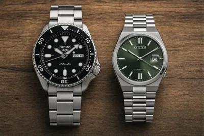 Citizen Tsuyosa e Seiko 5 Sports lado a lado sobre madeira escura, mostrando a diferença de altura