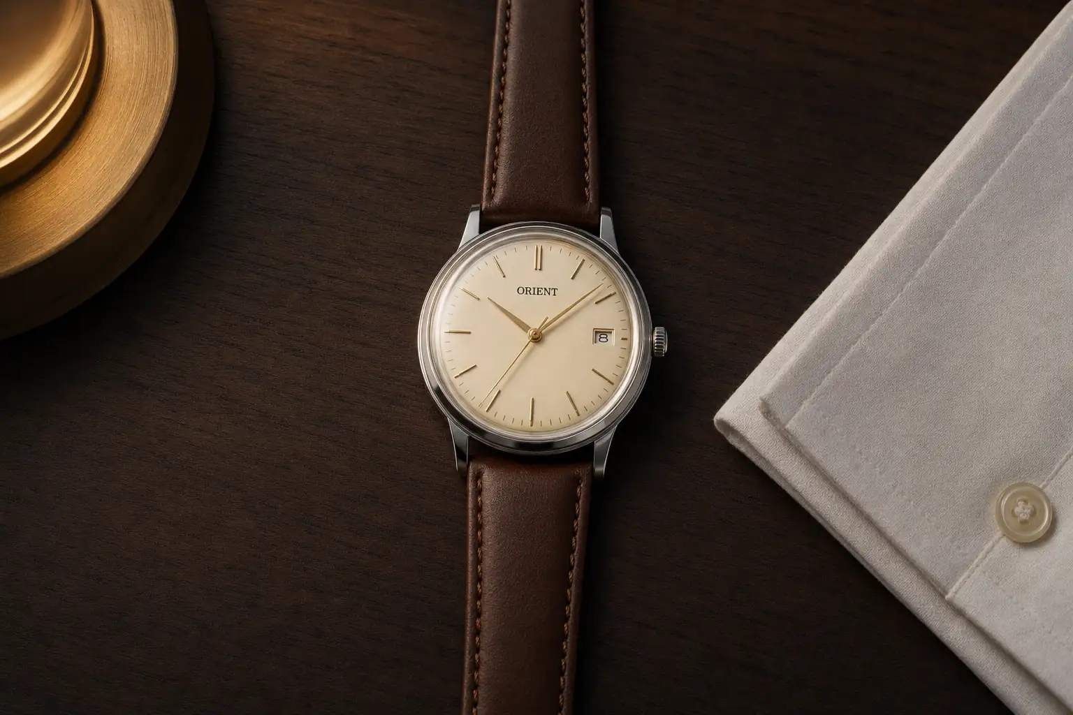 Orient Bambino de mostrador claro e pulseira de couro marrom sobre madeira escura