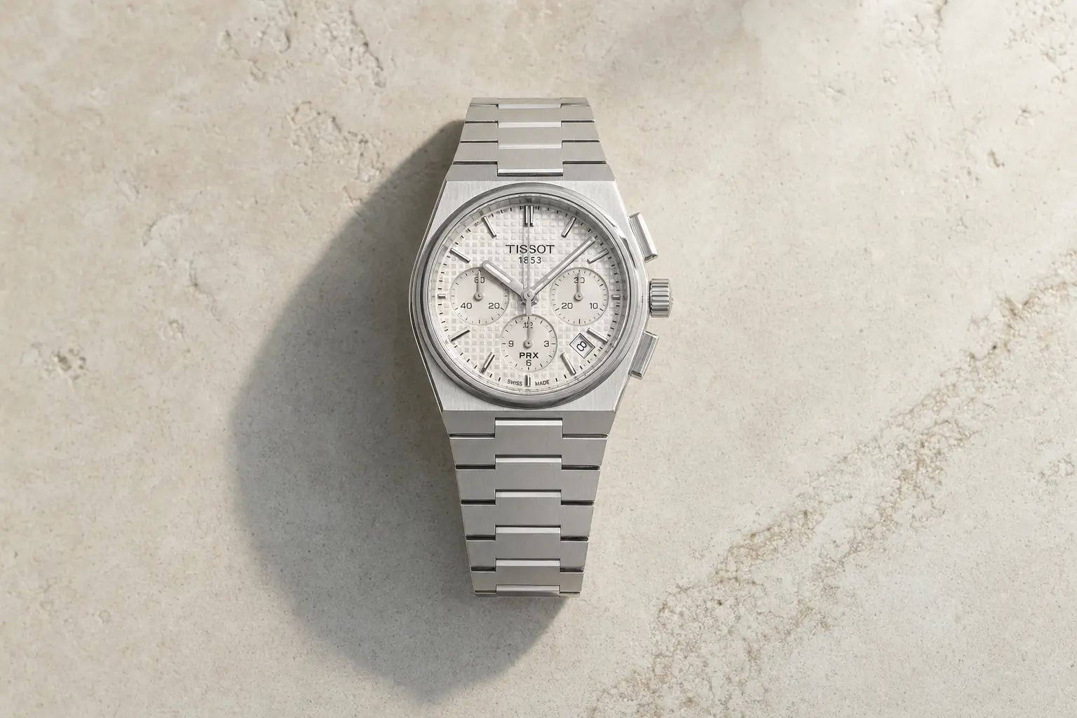 Tissot PRX Chronograph de 42 mm visto de cima sobre pedra clara