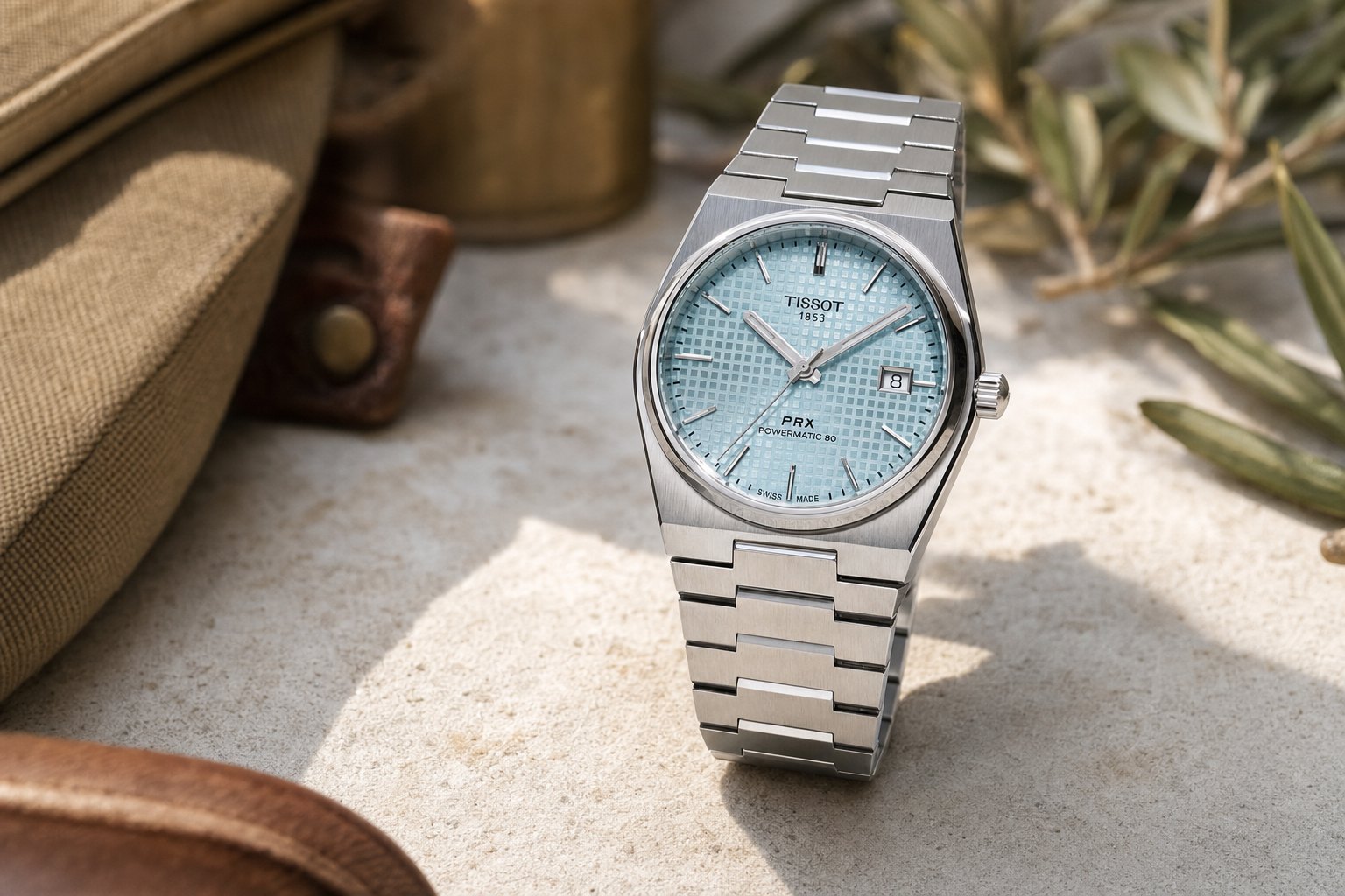 Tissot PRX Ice Blue de 40 mm sobre superfície clara, com o mostrador pegando luz