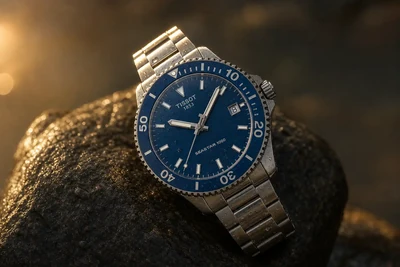 Tissot Seastar de mostrador azul e bisel de cerâmica sobre pedra molhada