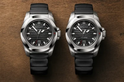 Dois Victorinox I.N.O.X. lado a lado sobre pedra escura, um de mostrador liso e outro com janela de movimento