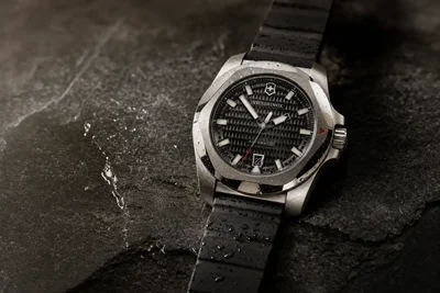 Victorinox I.N.O.X. de mostrador preto sobre pedra escura, com a caixa de aço à vista